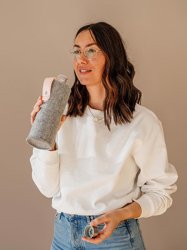 Girl drinking from EQUA glass water bottle Pink Breeze.