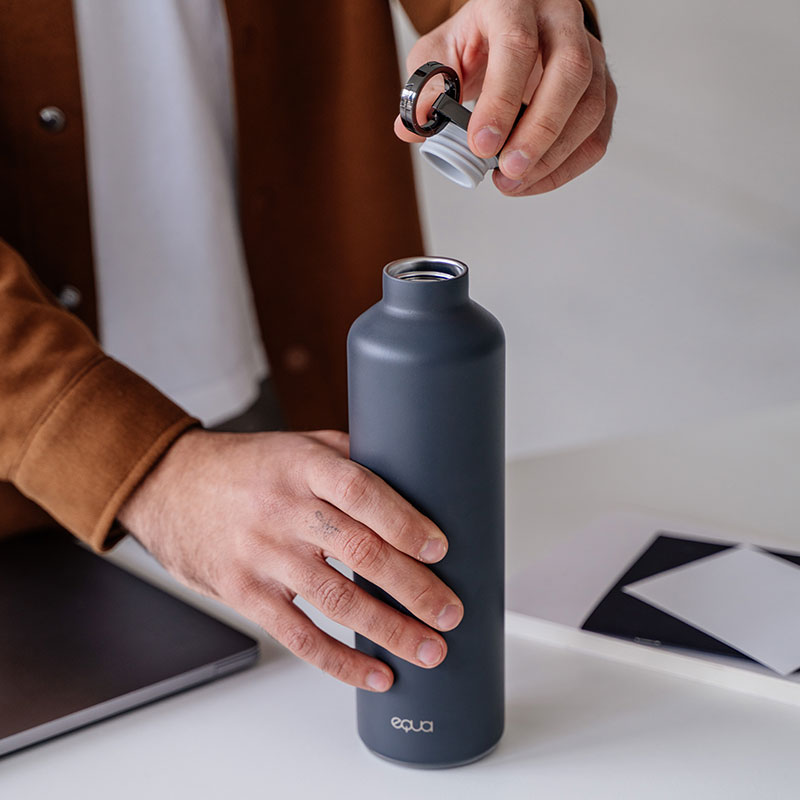 EQUA Smart Water Bottle v temno sivi barvi. S svetleče opomnike in aplikacijo, ki vam pomaga biti na poti z hidracijo. Obroč na pokrovu omogoča enostavno prenašanje steklenice. Izdelana iz dvojnega zidnega nerjavečega jekla z dodatnim bakrenim premazom.