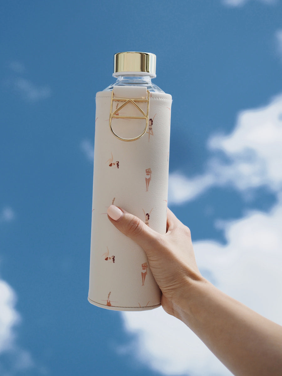 EQUA botella de agua de vidrio Playa con detalles dorados con fondo de cielo