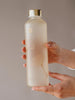 EQUA botella de agua de vidrio Ginkgo con acabado mate y detalles dorados.