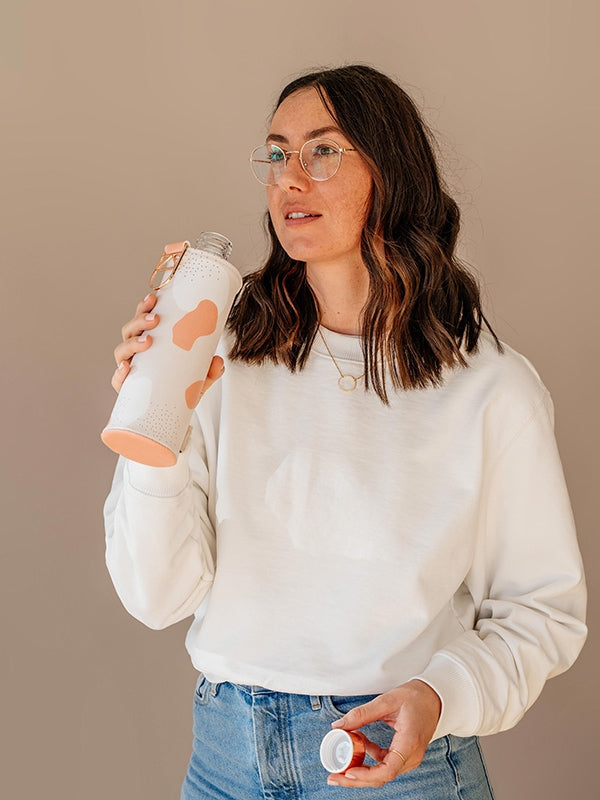 Girl drinking from EQUA glass water bottle Heavens.