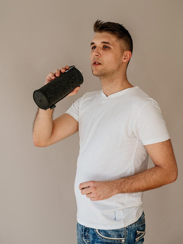 Boy drinking from EQUA glass water bottle Silver.