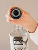 Botella de agua de cristal de piedra de EQUA abierta y con la tapa al aire exponiendo el interior de la tapa y la boca de la botella de agua. 