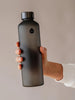 Botella de agua de cristal Ash de EQUA en color negro y con acabado negro mate que le da un aspecto elegante y unisex.