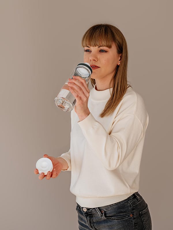 EQUA BPA FREE water bottle, Plain White, young woman drinking from the water bottle, minimalistic design, no motif, white color