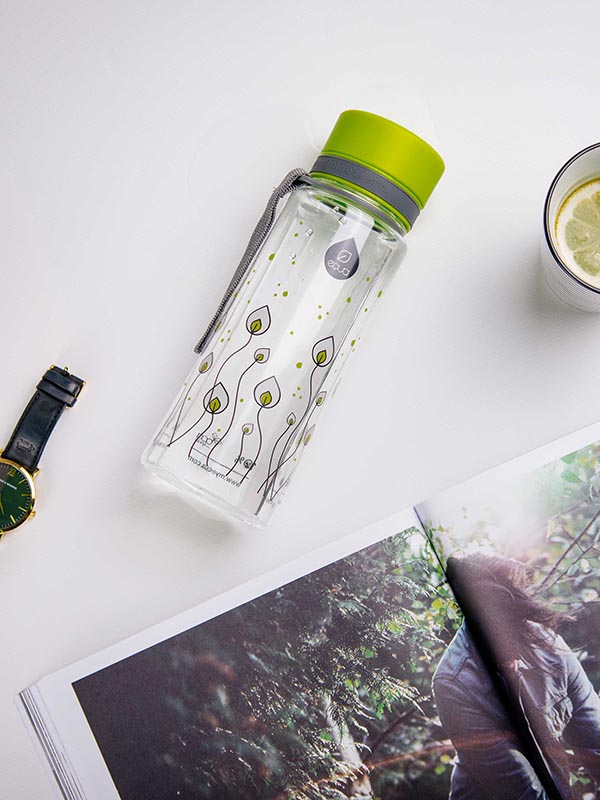 EQUA BPA FREE water bottle, Green leaves, water bottle on the table together with some tea and a magazine, motif of leaves, bright green and grey color