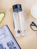 EQUA Bottiglia d'acqua BPA FREE, Plain Black, sul tavolo da pranzo, insieme a caffè, occhiali da lettura e una rivista, design minimalista, nessun motivo, nero