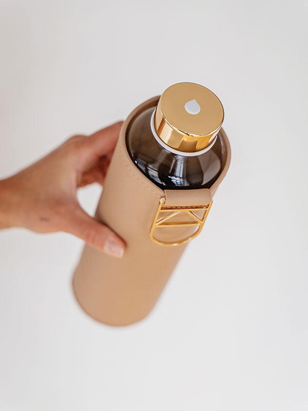 EQUA dettaglio del logo sul coperchio dorato della bottiglia d'acqua Sienna con copertura in finto vegano
