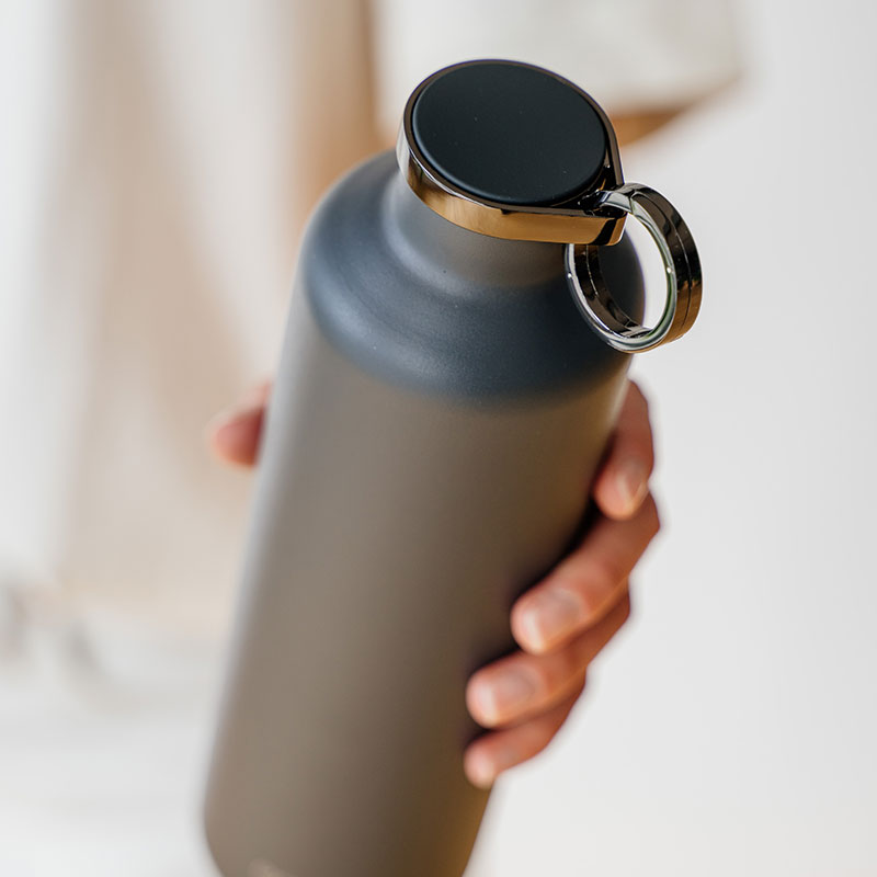 Stainless steel smart water bottle in dark grey colour. Unisex. With practical ring holder and metal lid.