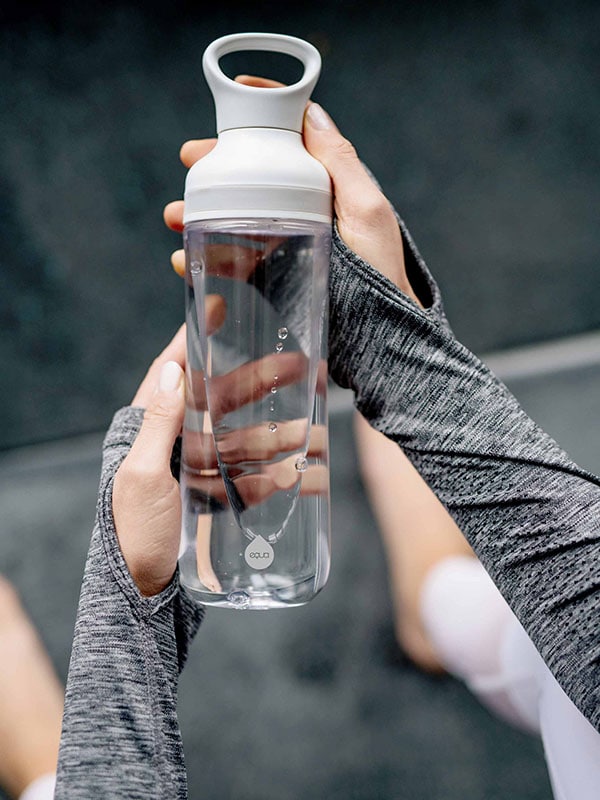EQUA Botella de agua FLOW SIN BPA, Freeze, primer plano de la botella sostenida en las manos, diseño minimalista, sin motivo, color gris