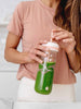 EQUA FLOW SANS BPA bouteille d'eau 2 in 1, Beat, la bouteille est montrée avec une paille, jeune femme regardant internet recettes de smoothie, motif, couleur pêche